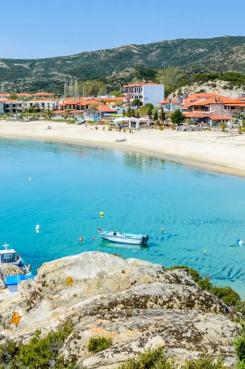 Agios Mamas beach with turquoise waters and seaside village