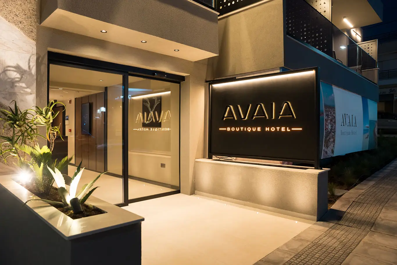 Illuminated entrance and Avaia Boutique Hotel sign at night in Moudania