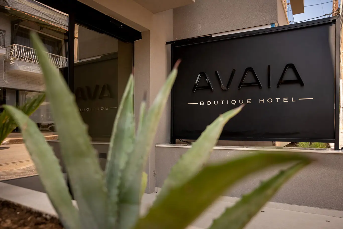 Avaia Boutique Hotel entrance sign in Moudania framed by decorative plants