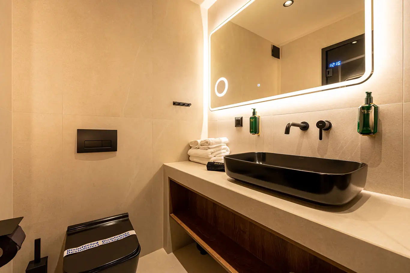 Modern bathroom vanity with black washbasin and illuminated mirror in Classic Luxury Room 101