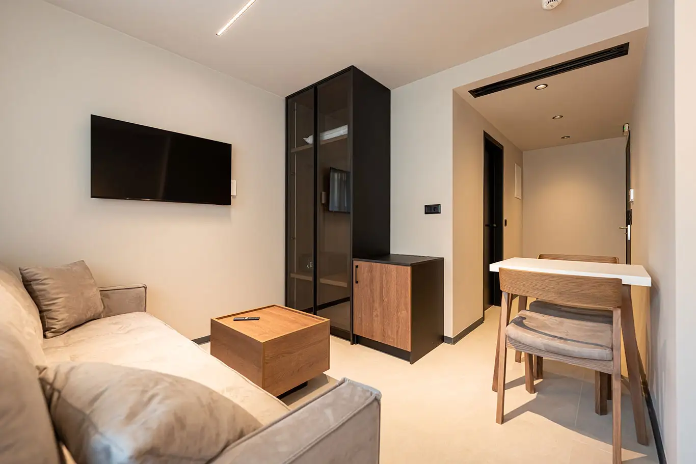 Living area with sofa, television, coffee table and dining table in Classic Luxury Room 101