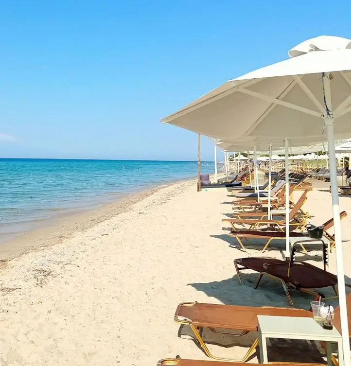 Flogita Beach with sunbeds and umbrellas along sandy shore