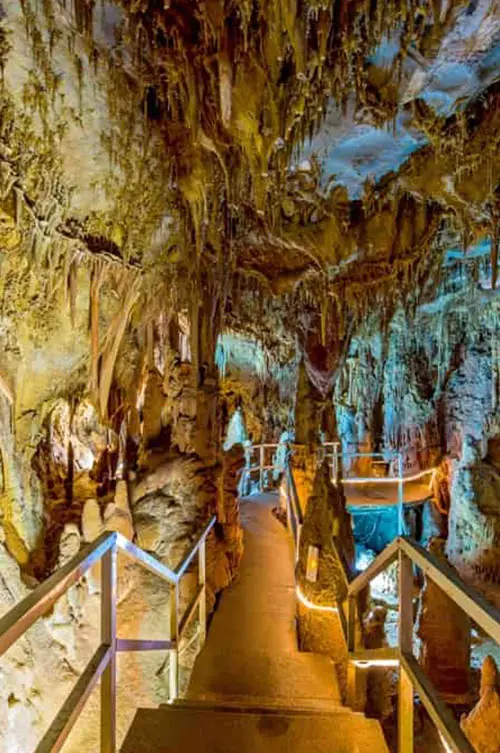 Interior of Petralona Cave with illuminated stalactites and walkway